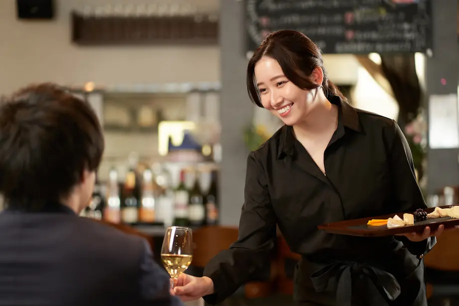 お客様に料理を提供する店舗スタッフ